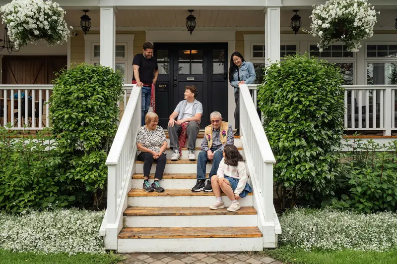 A family sitting together on the front steps of their home